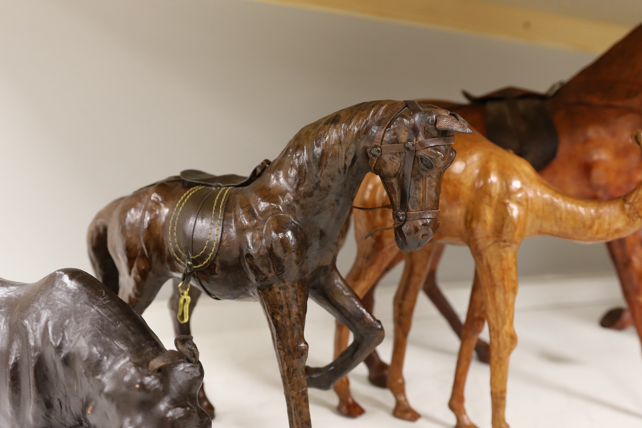 Two leather worked models of horses, a rhinoceros and a camel, tallest 42cm